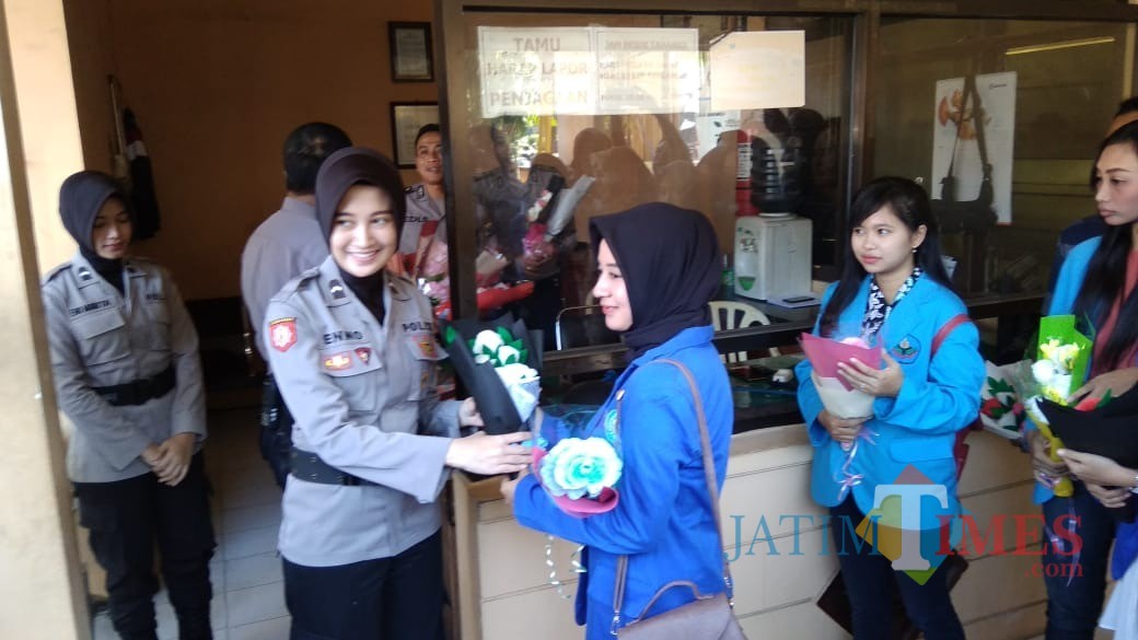 Mahasiswi dari tiga perguruan tinggi di Jember saat memberikan karangan bunga kepada polisi di Mapolres Jember (foto : Moh. Ali Makrus / Jatim TIMES)