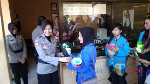 Mahasiswi dari tiga perguruan tinggi di Jember saat memberikan karangan bunga kepada polisi di Mapolres Jember (foto : Moh. Ali Makrus / Jatim TIMES)