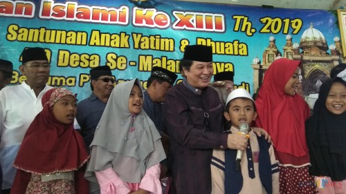 Komisaris Utama PT ACA Iwan Kurniawan (tengah) saat berbincang dengan anak-anak yatim di Kecamatan Bantur, Kabupaten Malang. (Foto: Nurlayla Ratri/MalangTIMES)