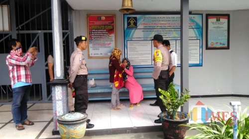 NL (baju pink) saat membelai anaknya yang digendong oleh neneknya di Lapas klas 2B Tulungagung (foto : Joko Pramono/JatimTIMES)