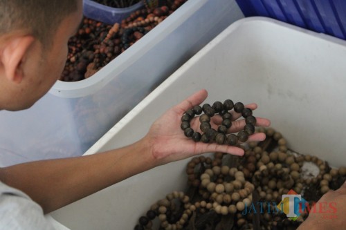 Pemilik produk kerajinan kayu gaharu saat menunjukkan berbagai macam gelang dan tasbih untuk dijual sebagai oleh-oleh lebaran. (Foto : Adi Rosul / JombangTIMES)