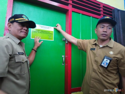 Kepala Disdag Kota Malang, Wahyu Setianto (Kiri) saat melakukan warning dengan penempelan stiker di kios pedagang yang menunggak( Anggara Sudiongko/MalangTIMES)