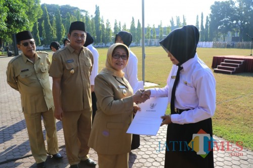 Bupati Jombang Hj Mundjidah Wahab menyerahkan SK CPNS seusai gelar apel dan halal bihalal di lapangan pemkab Jombang. (Foto : Adi Rosul / JombangTIMES)