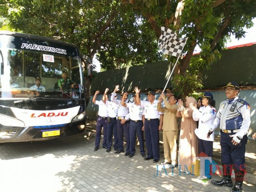 Wabup Situbondo (pegang bendera) saat melepas bus penumpang arus balik mudik gratis. (Foto Heru Hartanto / Situbondo TIMES)