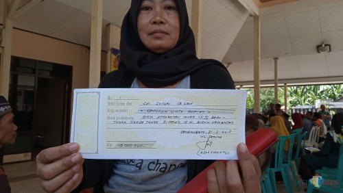 Warga tunjukan kuitansi pengurusan akta tanah.(foto : Joko Pramono/Jatim Times)