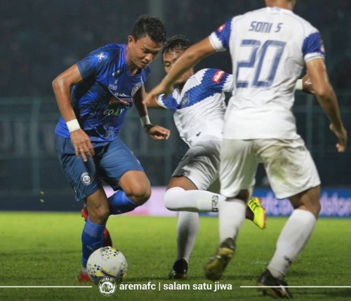 Dedik Setiawan (biru) saat diapit pemain lawan (official Arema FC)