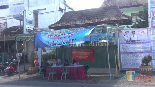 Sejumlah petugas PPDB saat berjaga di depan SMP 3 Tanggul selama proses PPDB (foto : f kosasih a / Jatim TIMES)