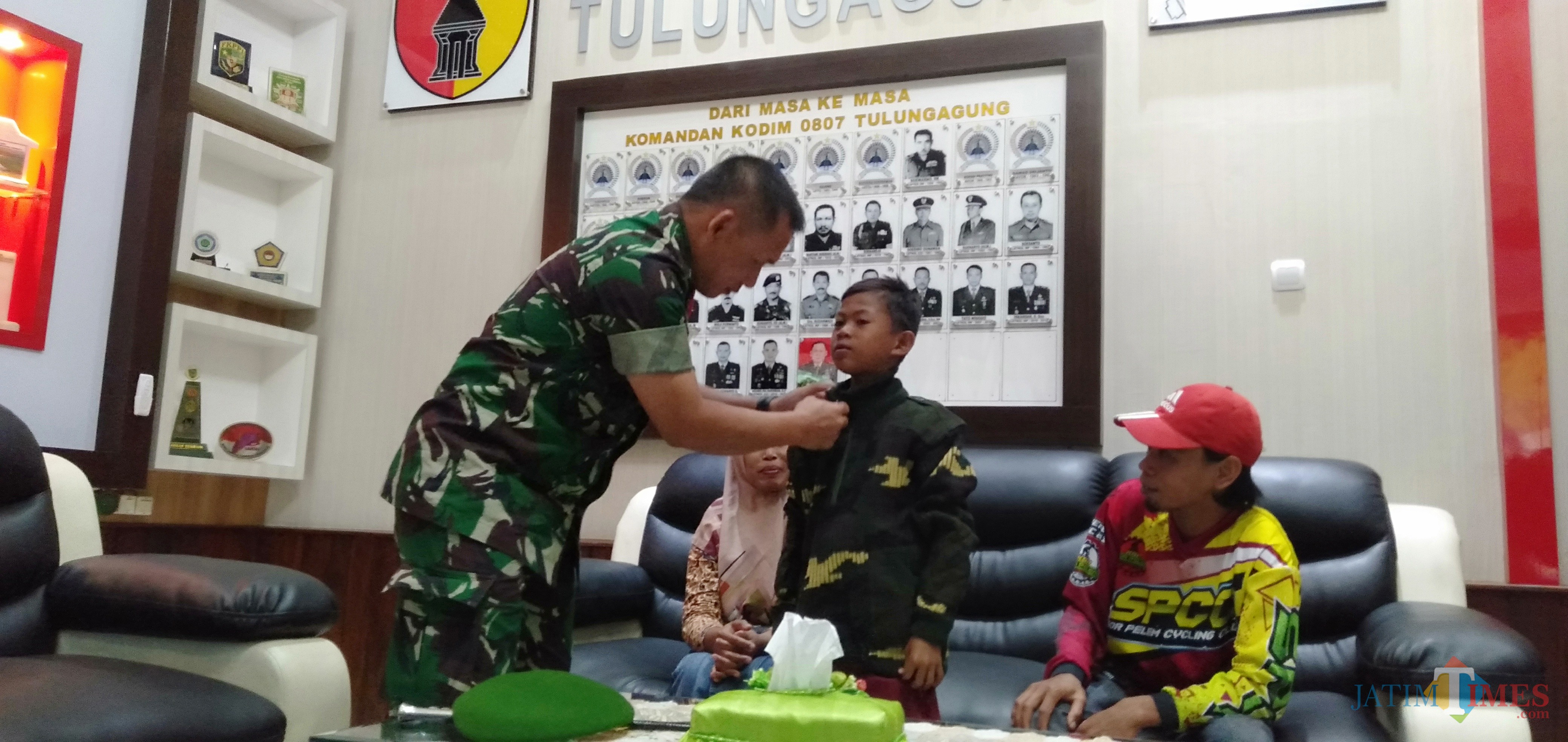 Komandan Kodim Tulungagung, Letkol Wildan Bahtiar saat memakaikan jaket doreng pada Soni (foto: Joko Pramono/JatimTIMES)