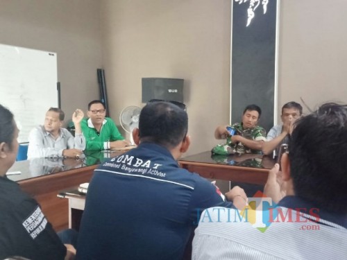 Kades Genteng Kulon Supandi (kaus hijau) didampingi pendamping desa Iqbalbsaat menjelaskan biaya PTSL kepada LSM Combat.