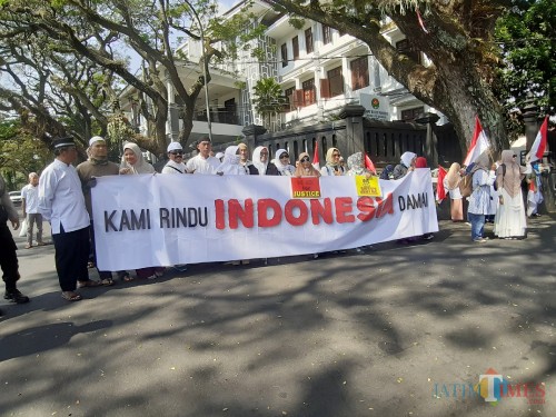 Massa yang mengatasnamakan KMPK menggelar aksi damai di depan gedung DPRD Kota Malang. (Arifina Cahyanti Firdausi/MalangTIMES)