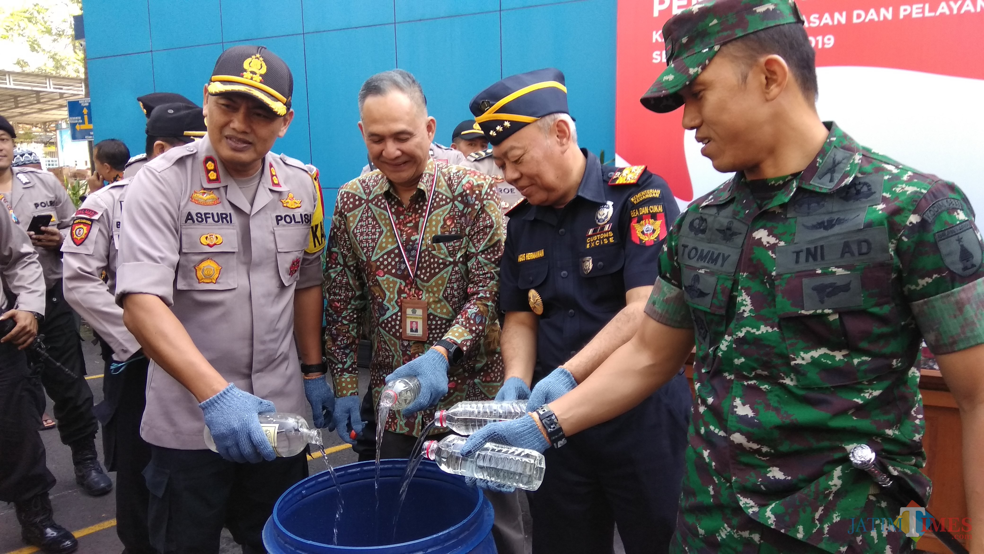Kepala Kanwil DJP III Jatim Rudy Gunawan Bastari (dua dari kiri) saat mengikuti pemusnahan miras ilegal di Kota Malang. (Foto: Nurlayla Ratri/MalangTIMES)