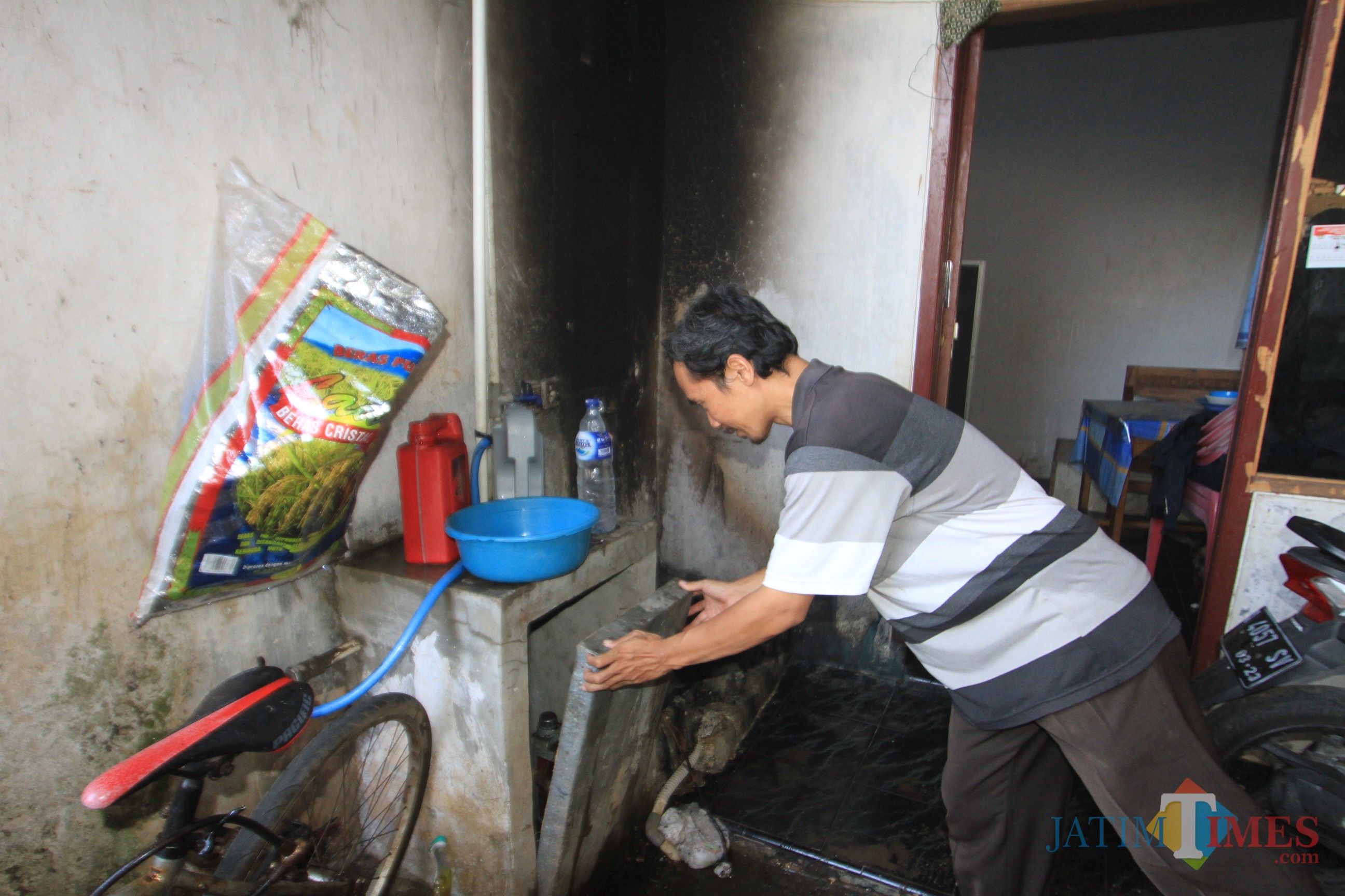 Sahroni menunjukkan tempat mesin cucinya yang terbakar (Agus Salam/Jatim TIMES)