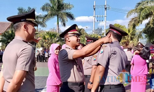 Prosesi penyematan pangkat saat prosesi upacara korps raport kenaikan pangkat di halaman Polres Batu, Selasa (2/7/2019). (Foto: Irsya Richa/MalangTIMES)