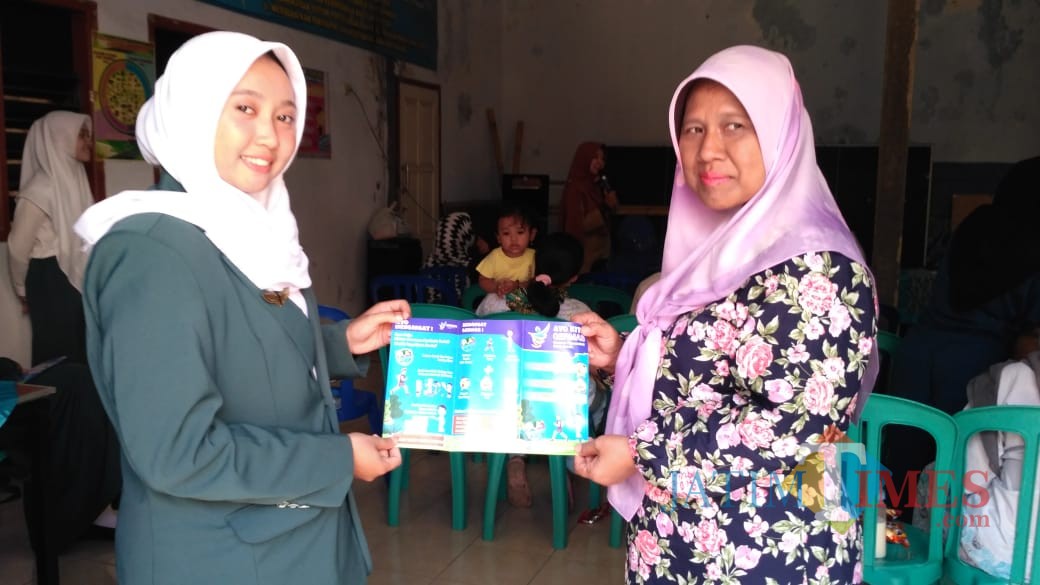 Salah seorang warga dan petugas kesehatan yang menunjukkan pamflet GERMAS saat penyuluhan (Arifina Cahyanti Firdausi/MalangTIMES)