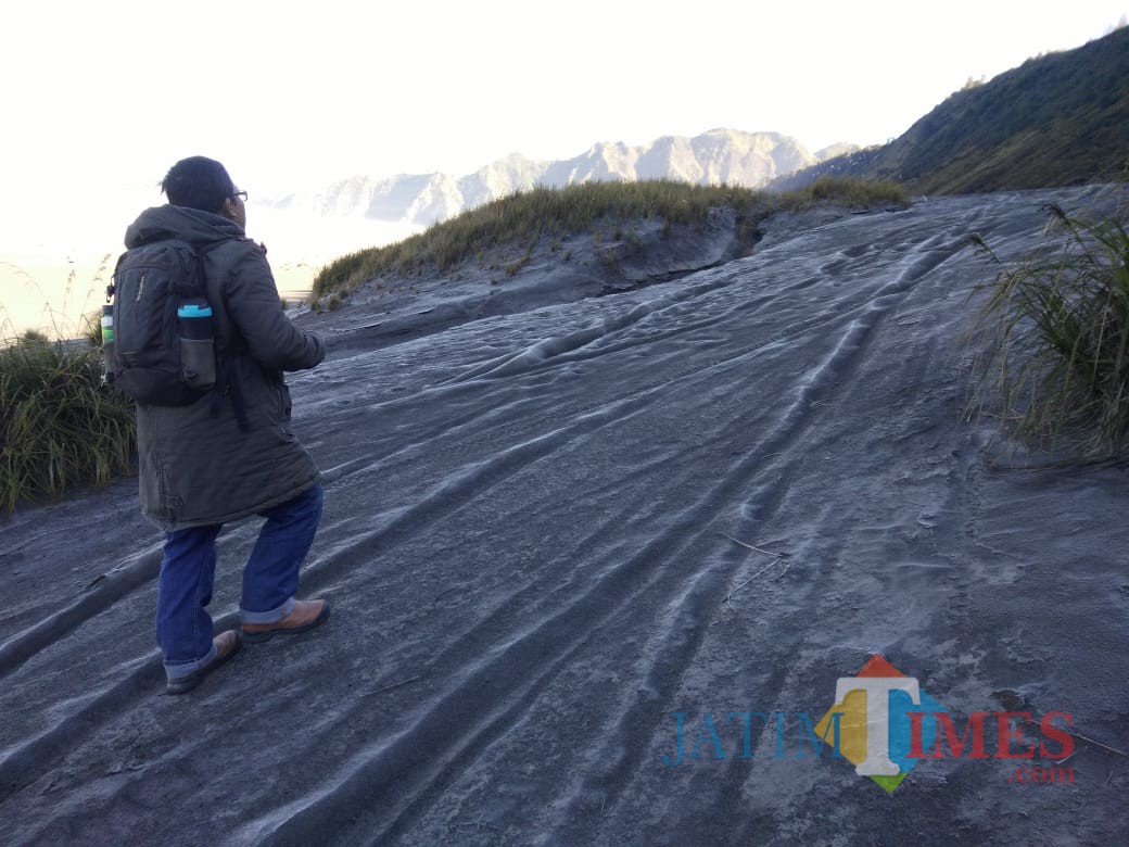 Wisatawan tengah berada di lautan pasir Gunung Bromo yang permukaannya diselimuti embun beku seperti salju. (Foto: Dokumen MalangTIMES)