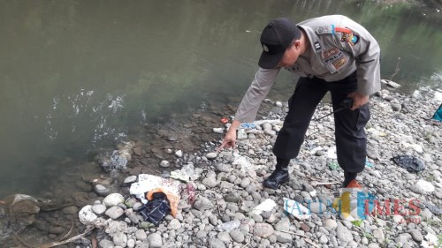 Petugas Polsek Kaliwates saat melakukan olah TKP penemuan mayat bayi yang terbungkus plastik. (foto : istimewa / Jatim TIMES)