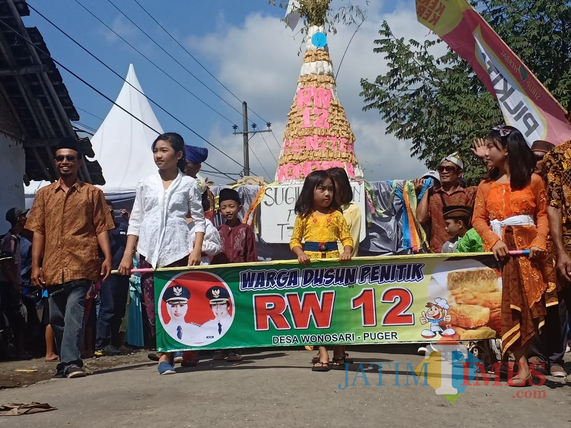 Warga mengarak tumpeng yang dibuat dari tahu dan tempe keliling desa (foto : R. Ulum / Jatim TIMES)