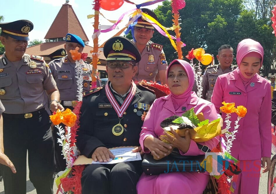 Kapolres Banyuwangi AKBP Taufik HZ mengayuh becak untuk mengantar anggota yang memasuki masa pensiun