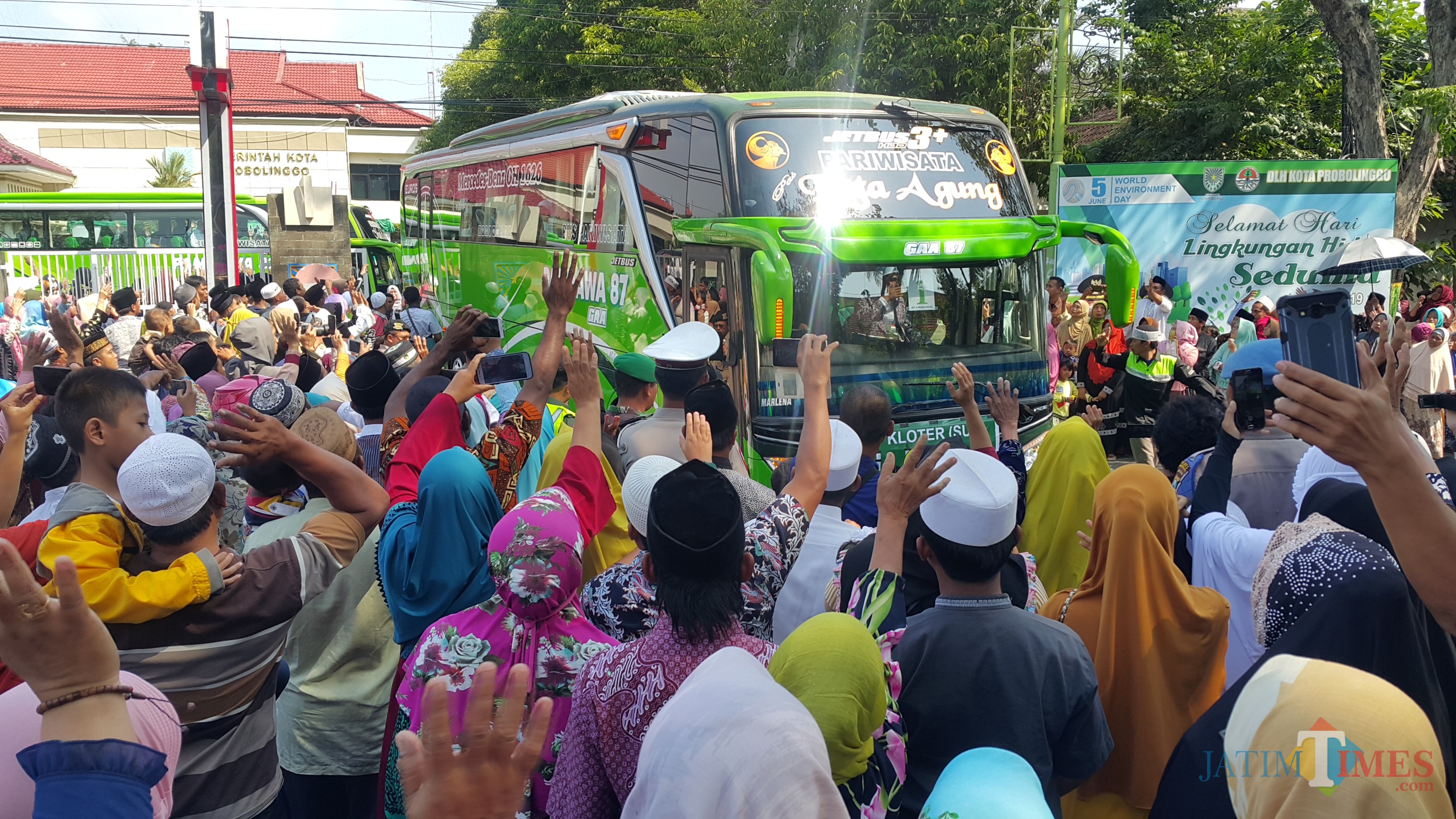 keluarga dan pengantar JCH melambaikan tangannya saat JCH berangkat ke Surabaya (Agus Salam/Jatim TIMES)
