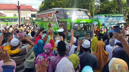 keluarga dan pengantar JCH melambaikan tangannya saat JCH berangkat ke Surabaya (Agus Salam/Jatim TIMES)