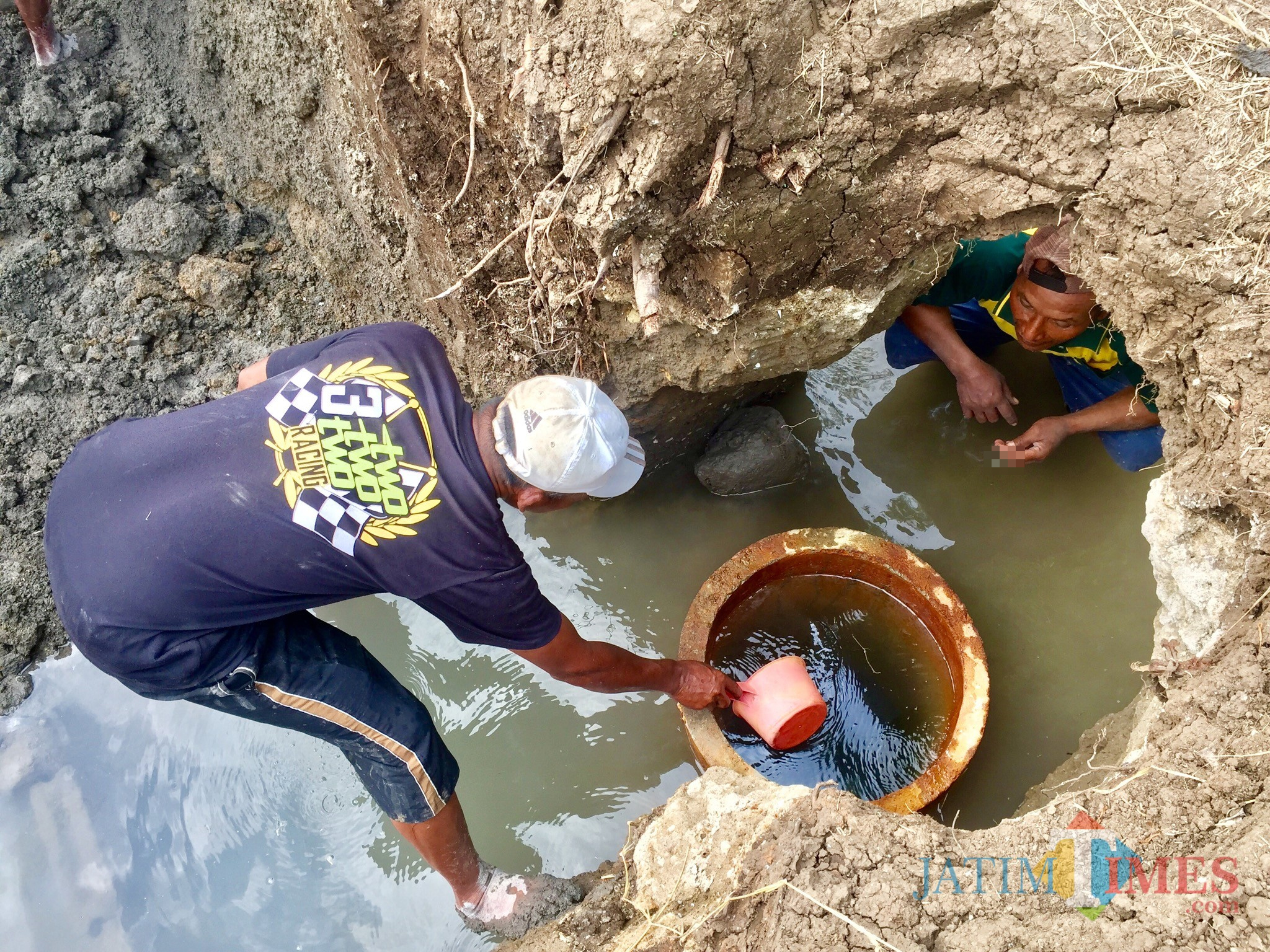 Warga saat menyiduk air sumber air hangat di Sumber Nyi Sindu Dusun Sumbersari, Desa Sumberejo, Kecamatan Batu, Kamis (11/7/2019). (Foto: Irsya Richa/MalangTIMES)