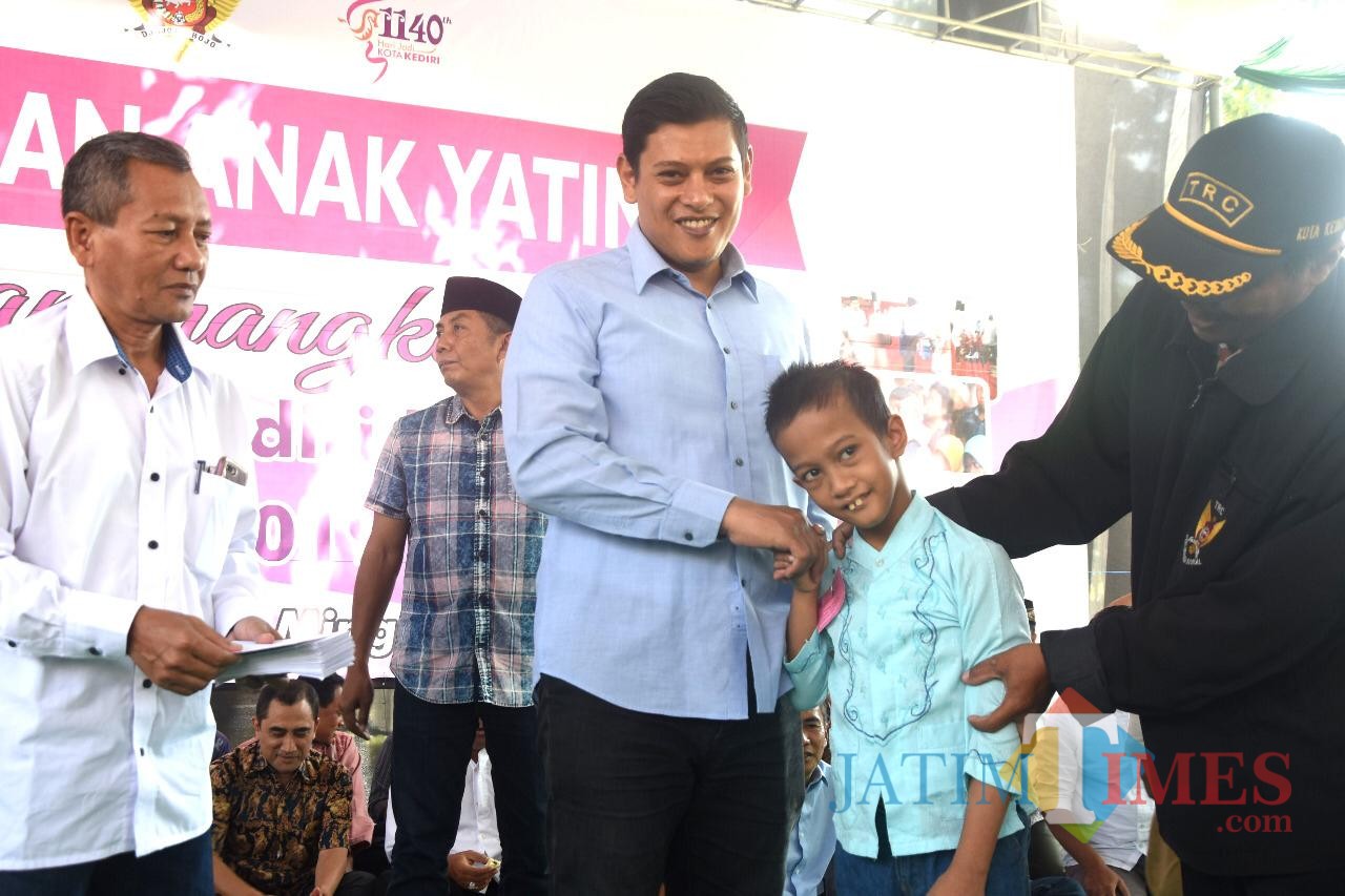 Walikota Kediri Abdullah Abu Bakar saat memberikan santunan kepada anak yatim. (eko Arif s /JatimTimes)