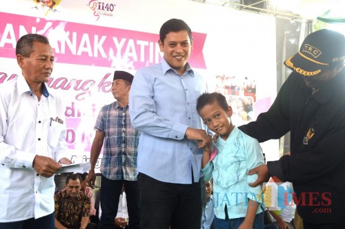 Walikota Kediri Abdullah Abu Bakar saat memberikan santunan kepada anak yatim. (eko Arif s /JatimTimes)