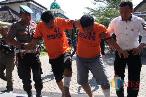 Kedua tersangka saat digelandang petugas di Mapolres Kediri. (eko Arif s /JatimTimes)