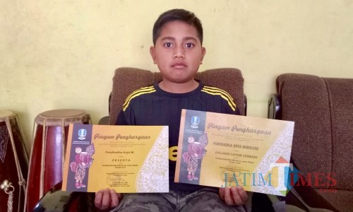 Arya saat menunjukkan sertifikat kejuarannya di rumahnya Dusun Songgoriti, Keluruhan Songgokerto, Kecamatan Batu. (Foto: Irsya Richa/MalangTIMES)