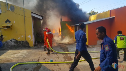 Petugas damkar tengah berusaha memadamkan api yang membakar gudang penyimpanan kardus dan plastik (Agus Salam/JatimTIMES)