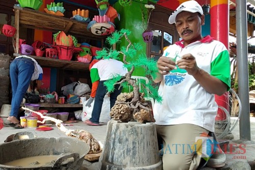 Salah satu warga saat memanfaatkan popok bekas untuk replika bonsai di Desa Torongrejo, Kecamatan Junrejo.
