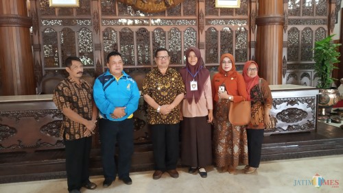 Dhea (seragam pramuka) berfoto dengan Plt bupati Tulungagung. (foto : Joko Pramono/Jatim Times)