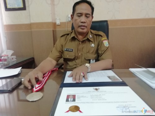 Kepala Dinas Pendidikan Kabupaten Malang M Hidayat saat memperlihatkan piagam prestasi istimewa dari LAN setelah 4 bulan dilatih dalam PKN 11 2019 (Nana)