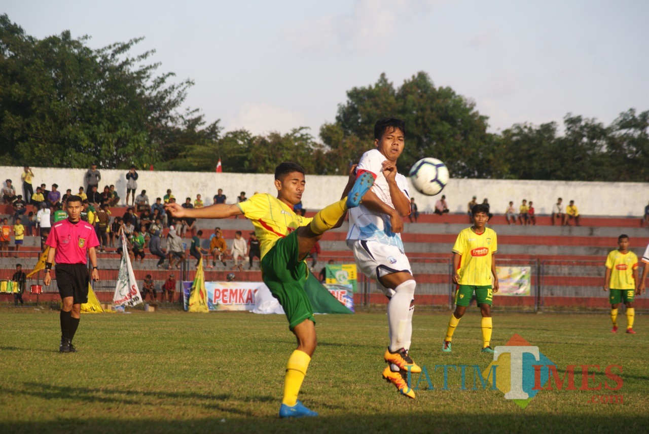 Pemain Perseta (kuning) berebut bola dengan pemain Perspa. (foto : Joko Pramono/Jatim Times)