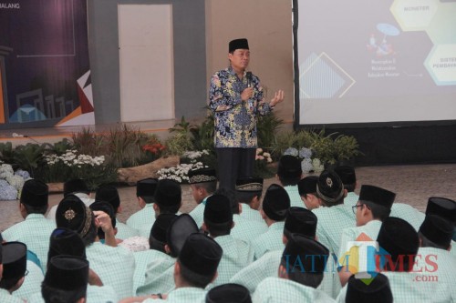 Kepala KPw BI Malang Azka Subhan (depan) saat mengajar di SMA Annur Bululawang. (Foto: BI Malang for MalangTIMES)