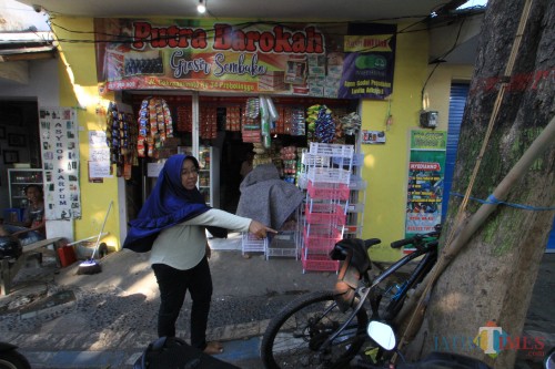 Livita pemilik toko menunjuk tempat parkir sepeda motor korban di depan tokonya (Agus Salam/Jatim TIMES)