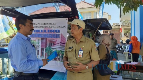 Kepala DPMPTSP Kabupaten Malang, Iriantoro (kanan) saat memberikan informasi kepada masyarakat ya g tengah mencari informasi di Sikeling (Pipit Anggraeni/MalangTIMES)