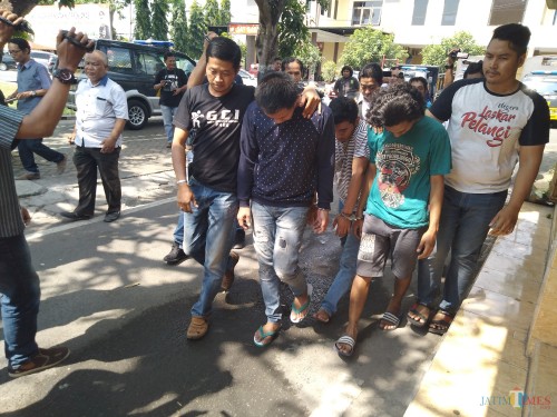 Mengenakan sweater biru, salah seorang ASN Pemkab Jombang saat diglandang Polisi ke Mapolres Jombang. (Foto : Adi Rosul / JombangTIMES)