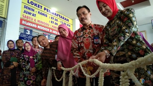 Supriyanto (batik merah) saat memotong untaian melati menandakan peresmian layanan Poetri dan Si Tole (foto : Joko Pramono/Jatim Times)