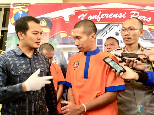 Tersangka saat memperagakan cara mengubah suara ketika melangsungkan aksinya di halaman Polres Batu. (Foto: Irsya Richa/MalangTIMES)