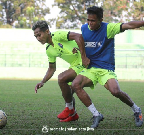 Ridwan Tawainella (kanan) saat berebut bola dengan Hendro Siswanto (official Arema FC)