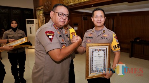 Kapolda Jatim Irjen Luki Hermawan (kiri) saat menyerahkan piagam penghargaan kepada Kapolres Jember AKBP Kusworo Wibowo. (foto : istimewa / Jatim TIMES)