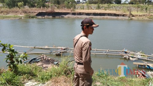 anggota Satpol PP Jatim saat melihat alat penyedot pasir yang masih tergeletak di sekitar sungai di Desa Tapan, Kedungwaru (foto : Joko Pramono/Jatim Times)