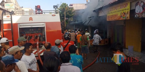 Petugas saat berusaha memadamkan api di ruko yang ada di Pasar Semboro (foto : R Ulum / JatimTIMES)