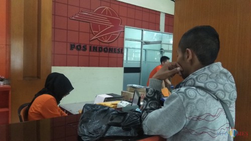 Warga tengah mengirimkan paket di Kator Pos Malang. (Foto: Nurlayla Ratri/MalangTIMES)
