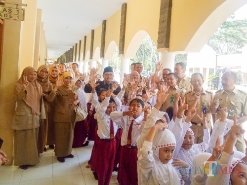 Kepala Dinas Pendidikan Kota Malang, Dra Zubaidah MM, dan Wali Kota Malang, Sutiaji, berfoto bersama siswa-siswi saat melakukan monitoring pelaksanaan Penguatan Pendidikan Karakter (PPK). (Foto: Imarorul Izzah/MalangTIMES)