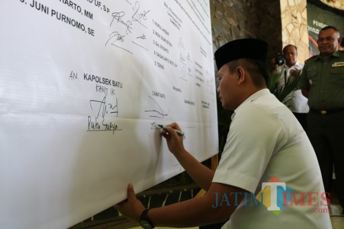 Camat Batu Yopi Supriadi saat menandatangani deklarasi damai di Pendopo Senopati Praja, Kecamatan Batu, Rabu (18/9/2019).