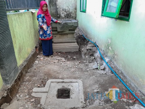 Kepala SDN Dinoyo 1 Nurul Hidayatus Shobikhah saat menunjukkan artefak yoni yang ditemukan di SDN Dinoyo 1. (Foto: Imarotul Izzah/MalangTIMES))