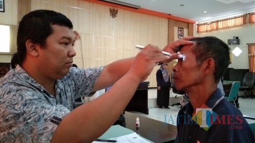 salah satu pasien diperiksa matanya oleh petugas kesehatan dalan screening di Dinkes Tulungagung (foto : Joko Pramono/ JatimTIMES)
