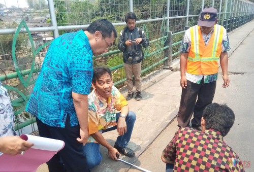 Kepala DPUPR Kota Malang, Hadi Santoso, saat melakukan pengukuran jalan di Jembatan Muharto (Anggara Sudiongko/MalangTIMES)